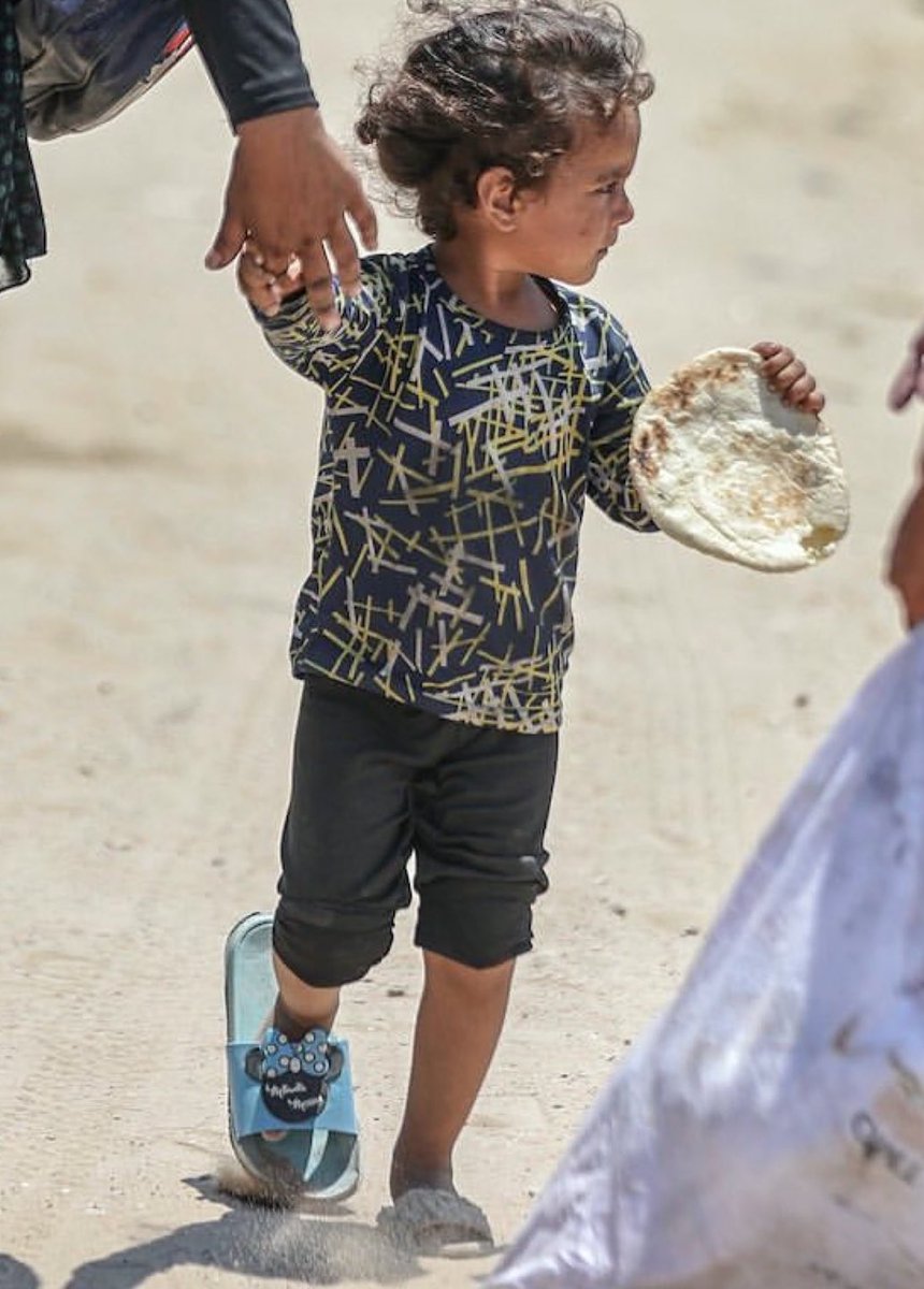A little girl, a bread loaf, and two different shoes