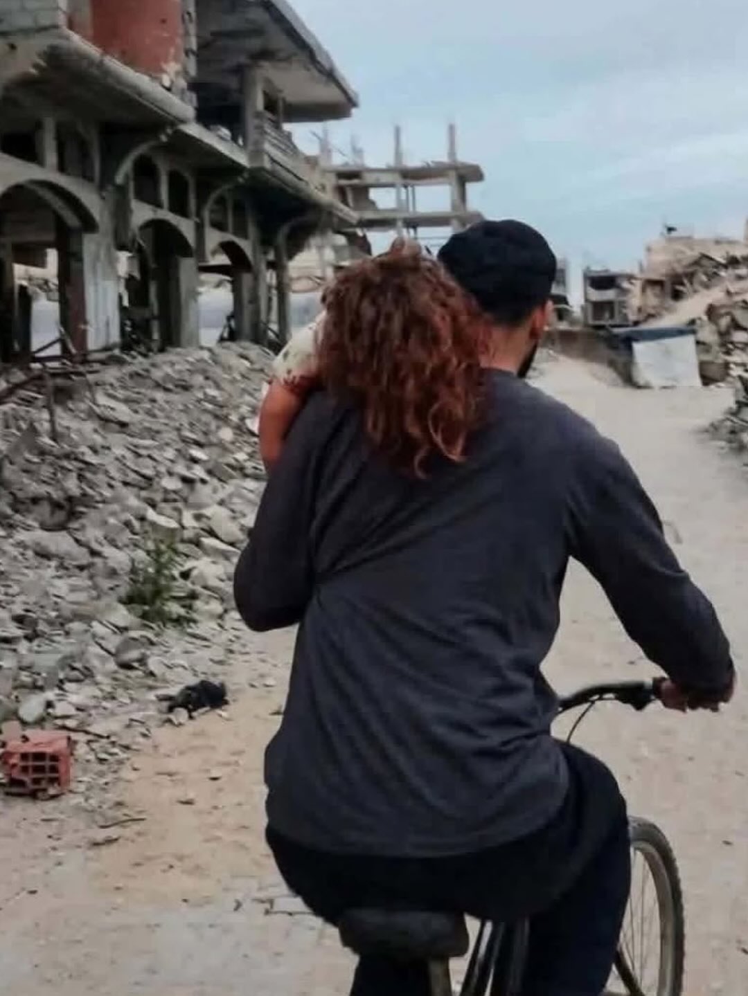 Father carries injured daughter on bicycle through Gaza ruins