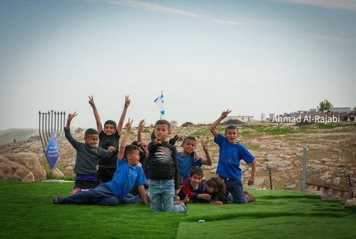 Children play in Umm al-Khair village playground amid Israeli restrictions