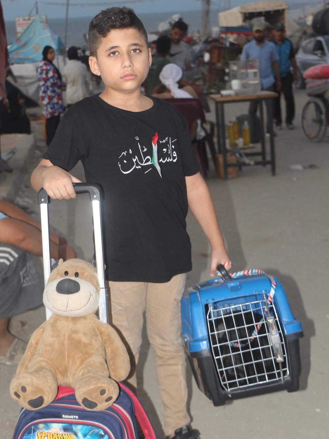 Child displaced in Gaza with belongings amid war ruins