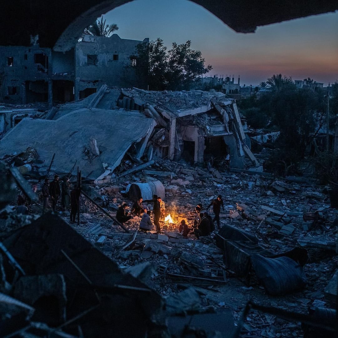 Palestinians gather around fire amid destroyed homes in Khan Younis