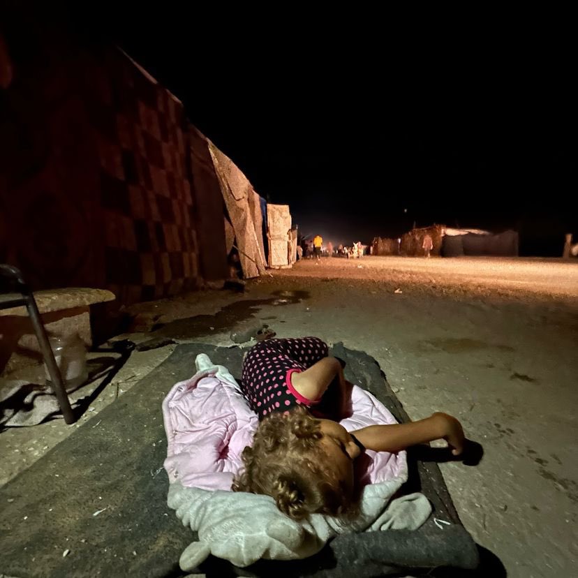 Displaced girl sleeps on street before family tent
