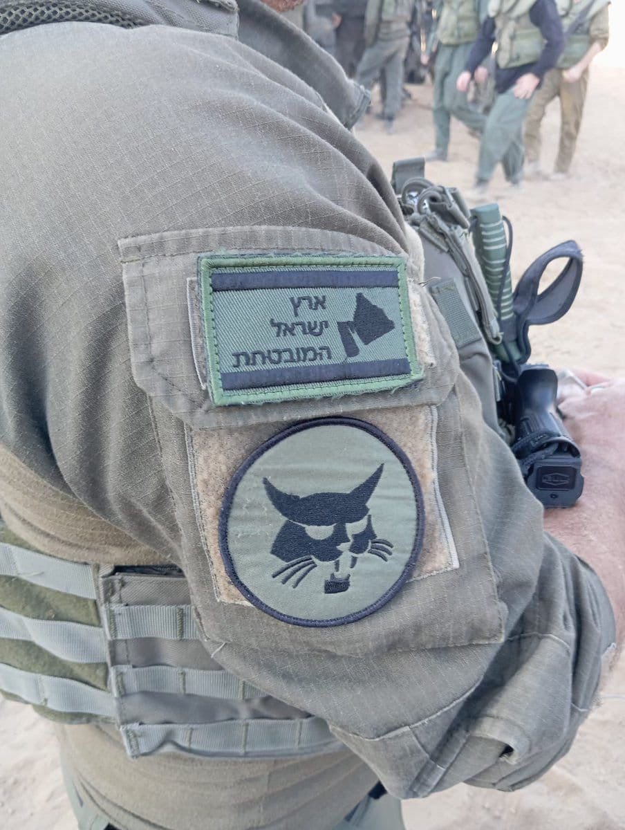 Israeli soldier displays Greater Israel map symbolizing territorial expansion