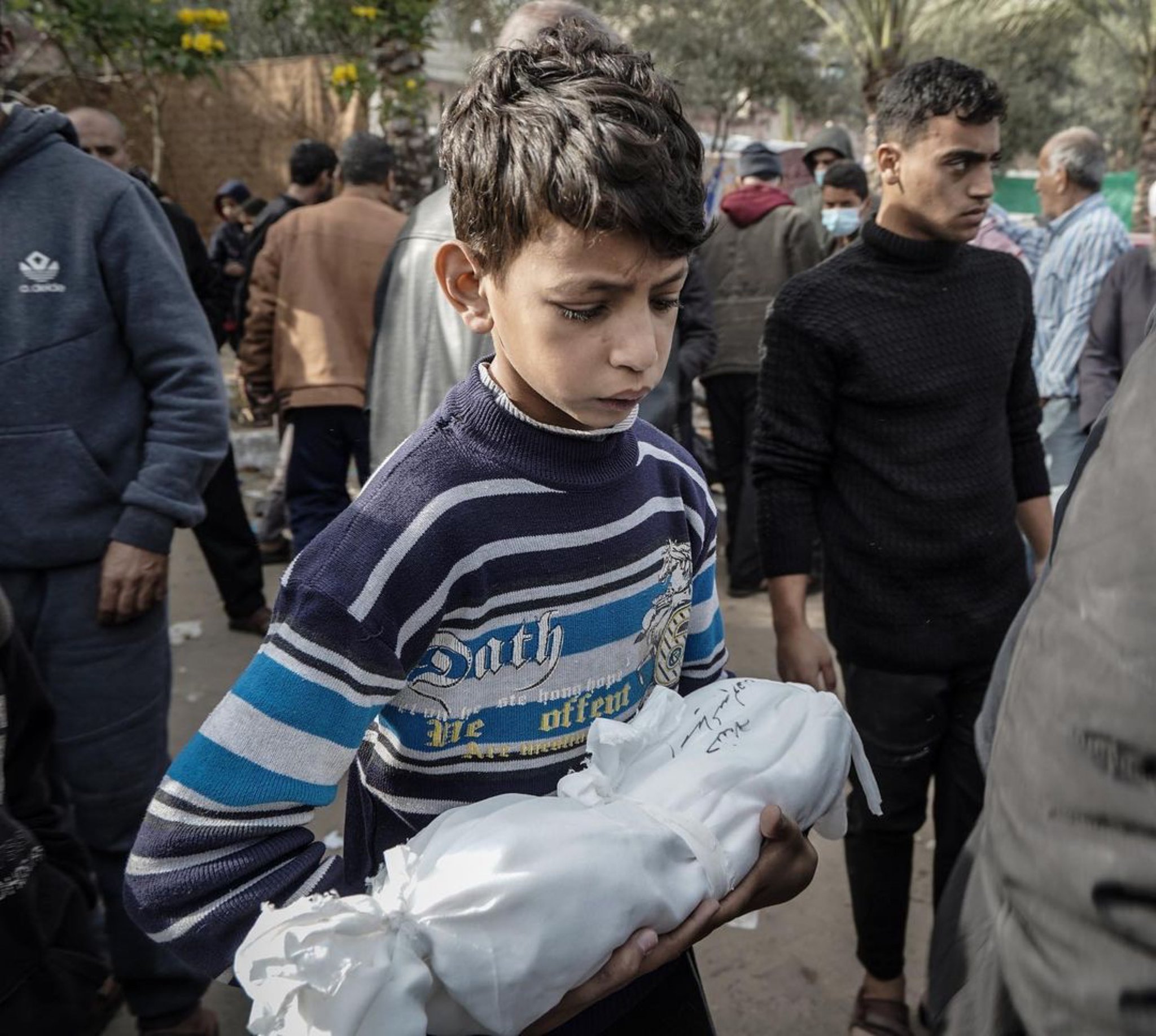 Child Carries Deceased Sibling After Israeli Bombing Khan Yunis