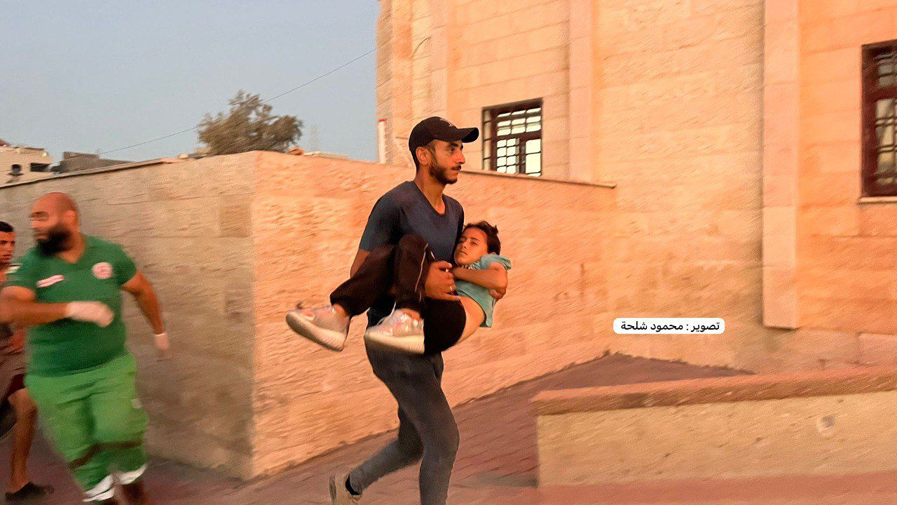 Palestinian father carries injured child from Israeli bombing in Gaza