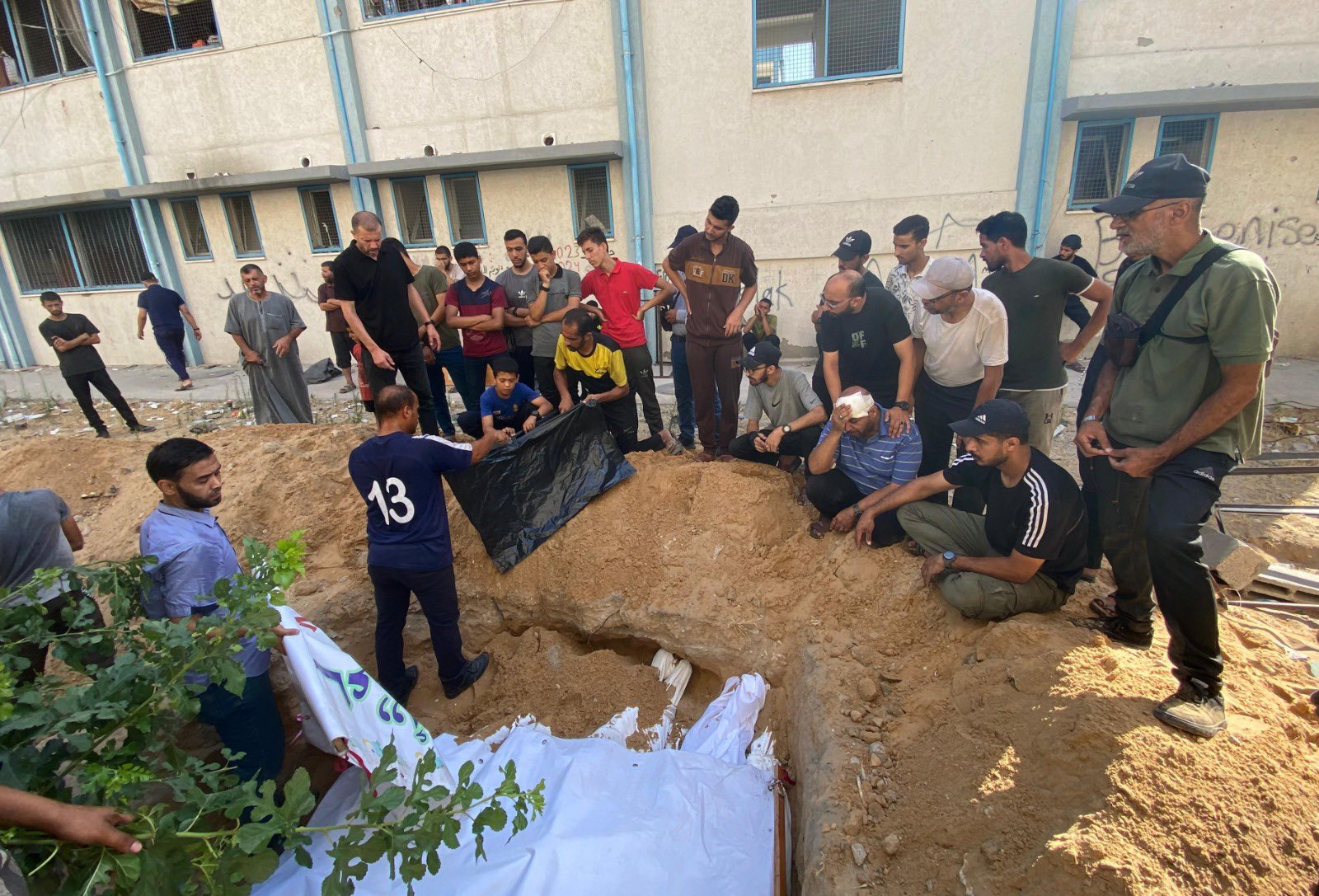 Displaced Persons Burying Victims of Israeli Bombing