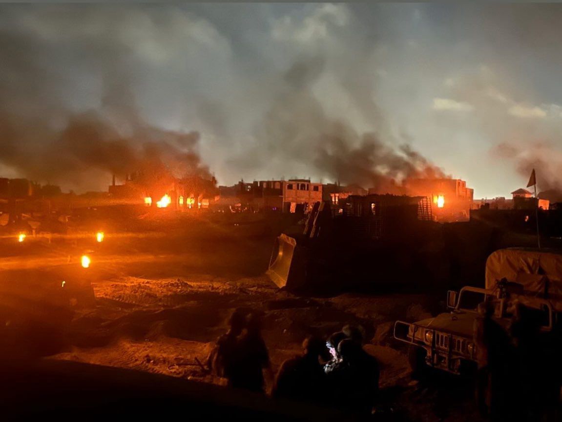 Israeli soldiers pose before burning Palestinian homes in Rafah