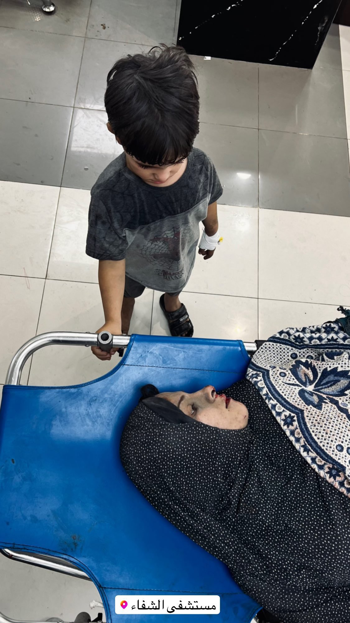 Child beside injured mother after Gaza airstrike