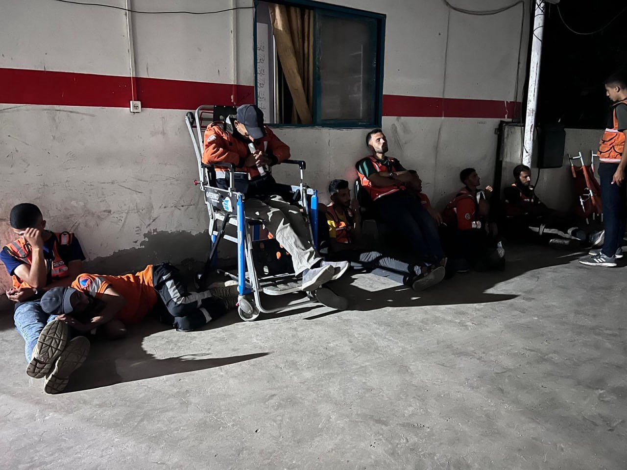 Gaza Civil Defense Workers Rest on Ground Amid Conflict