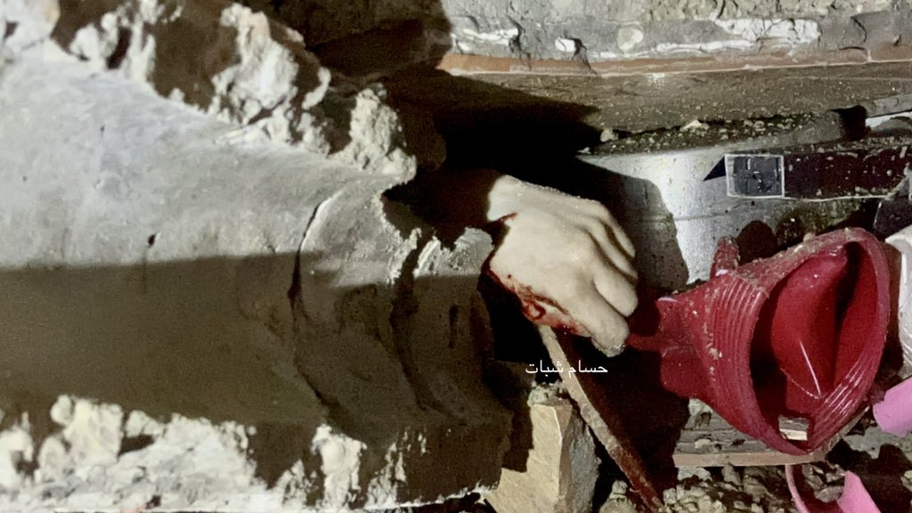 Woman’s hand emerges from rubble after house bombing
