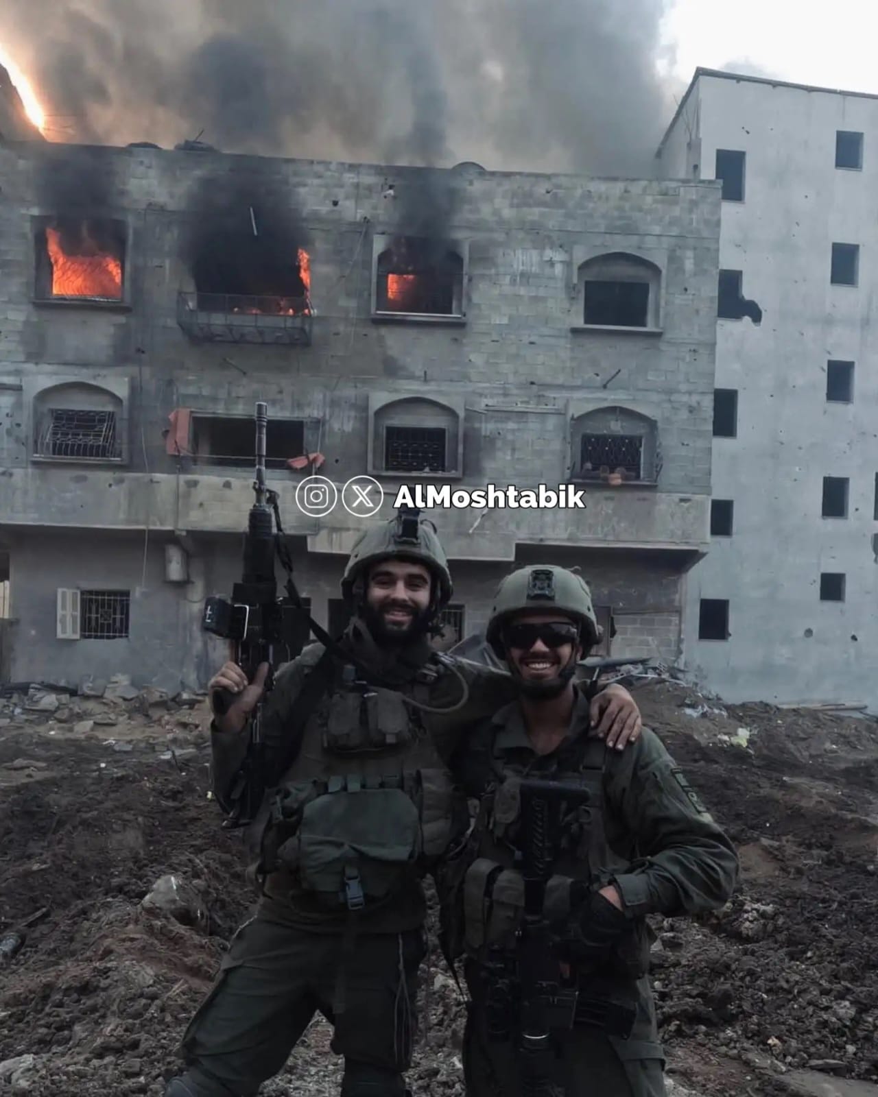 IOF soldiers posing with burning Palestinian home in Gaza