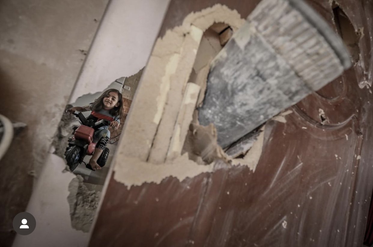Gaza girl rides bike through tank shell hole in her room