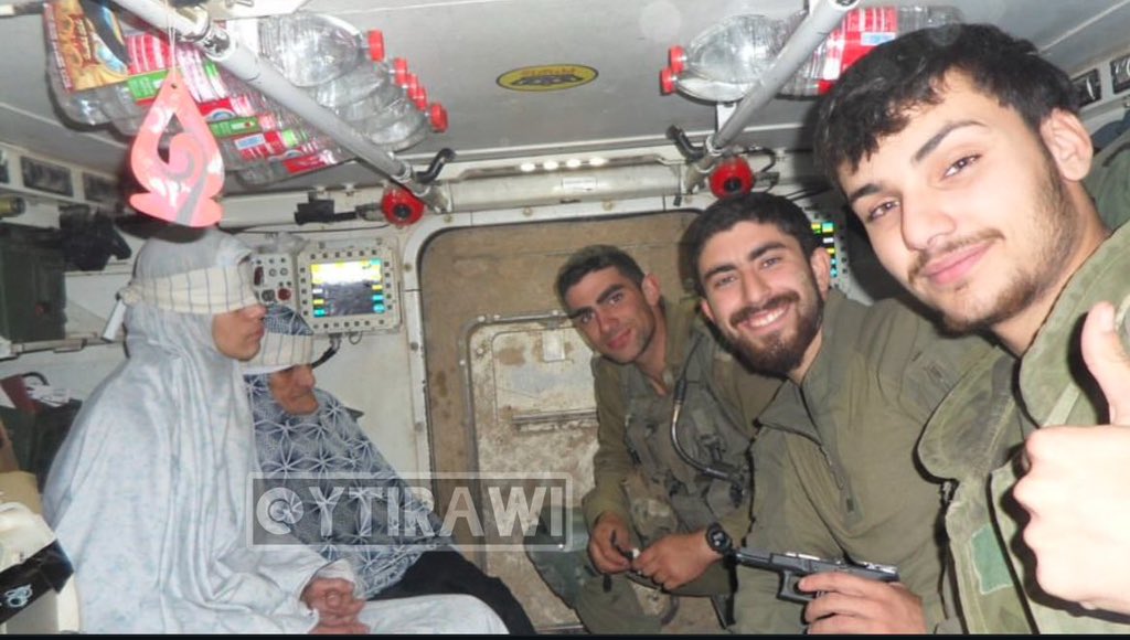 Israeli soldiers with blindfolded Palestinian detainees from Khan Younis