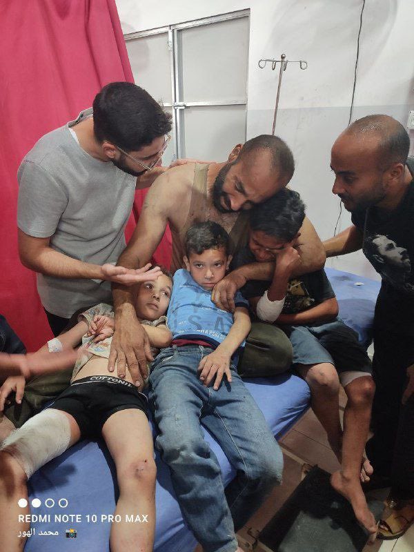 Wounded father embracing three injured children in Gaza hospital