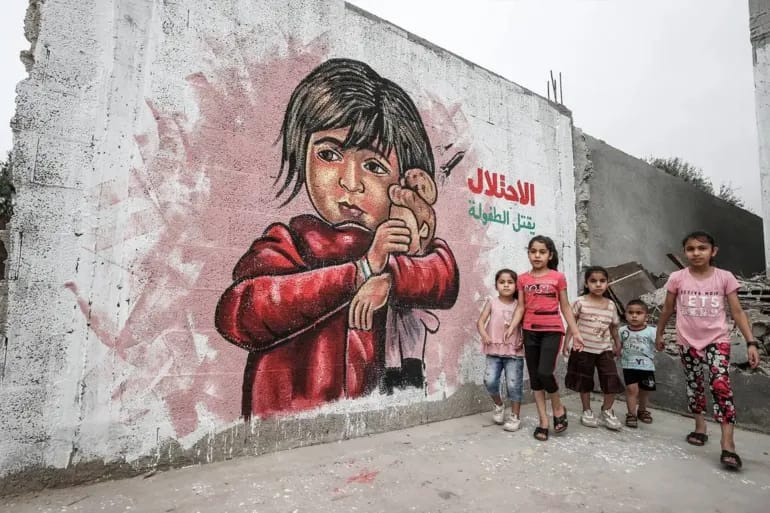 Palestinian Children Stand Before Mural on Demolished Homes