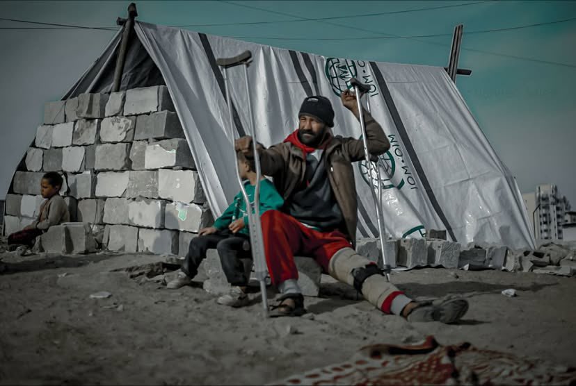 Wounded Man Shelters Child Amid Ruins of Destroyed Home