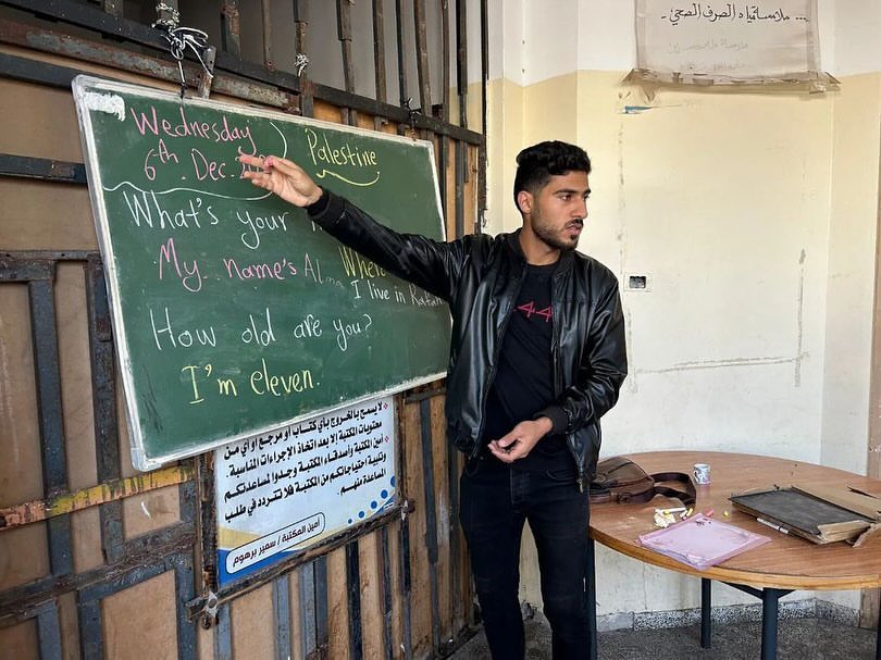 Palestinian youth Tarek Enabbi teaches children in Rafah shelter