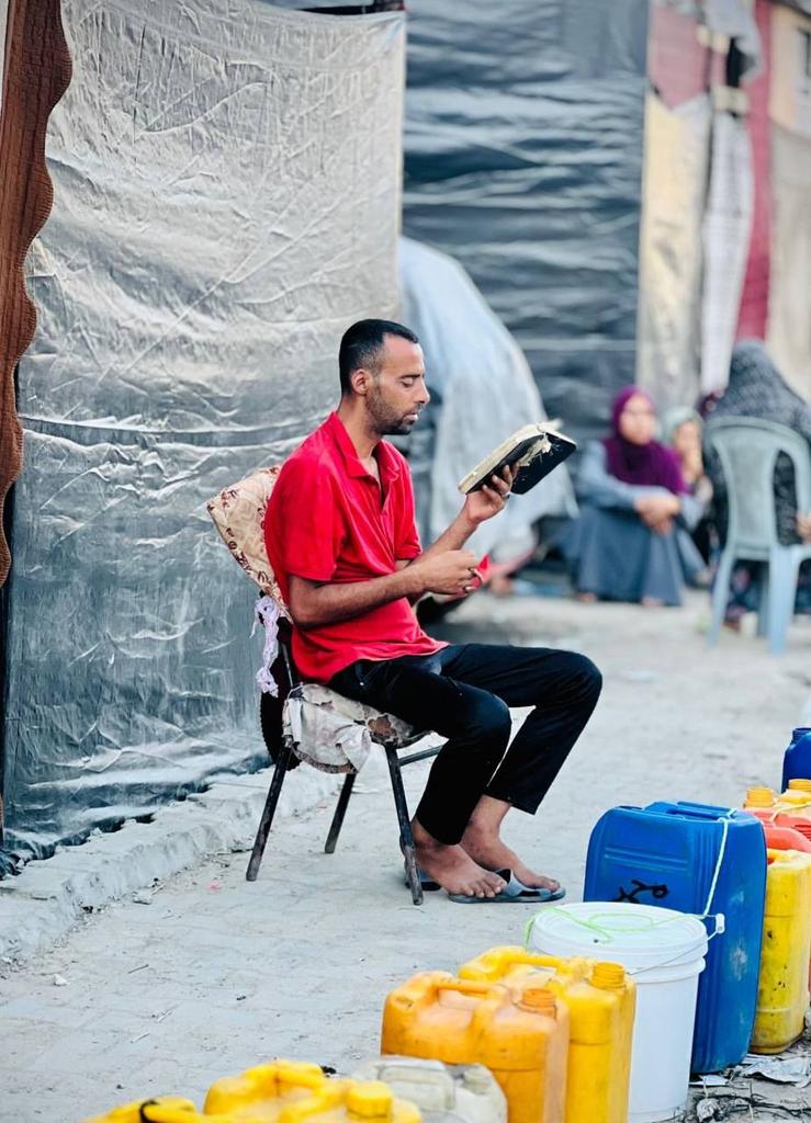 Palestinian youth recites Quran while waiting for water in Gaza