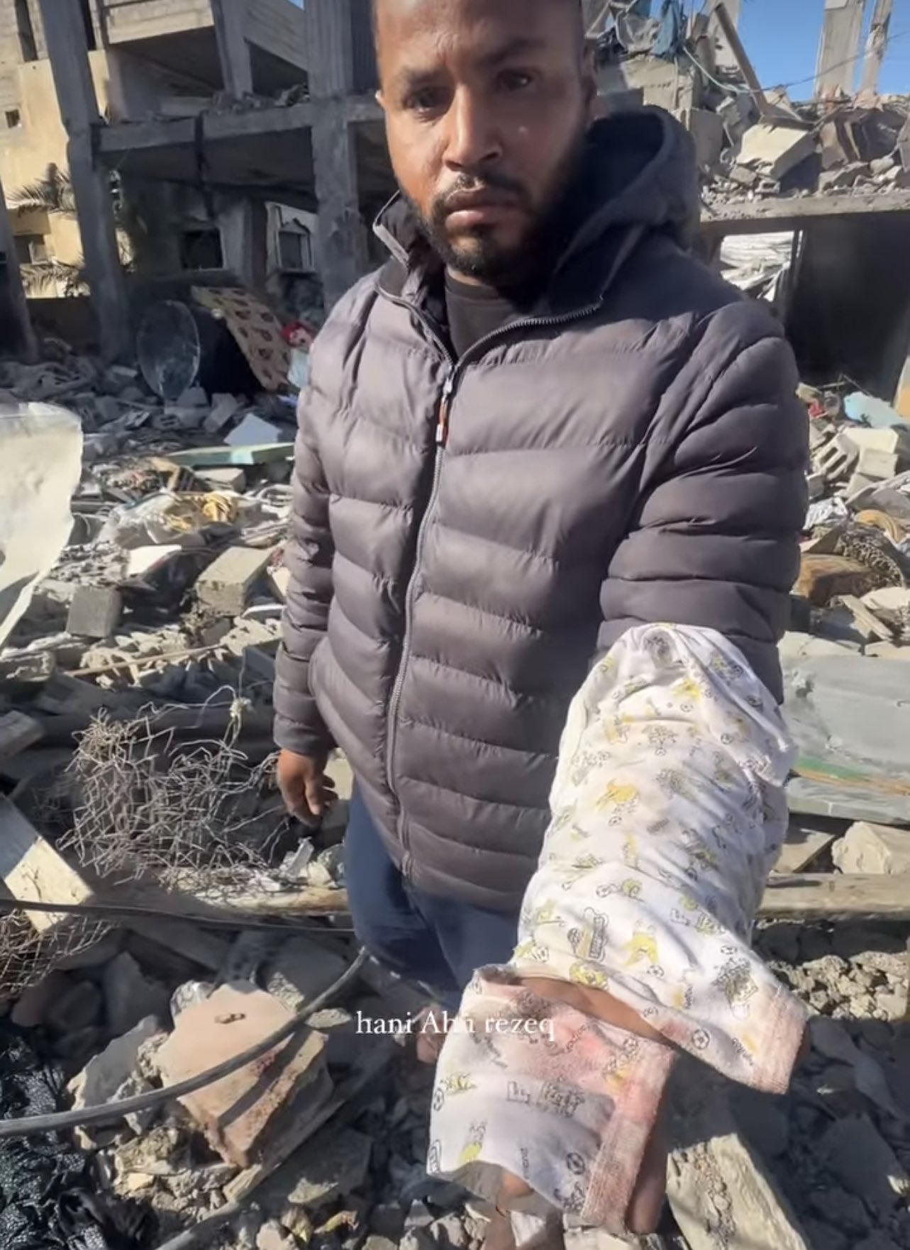 Palestinian father grieves baby clothes after Israeli airstrike