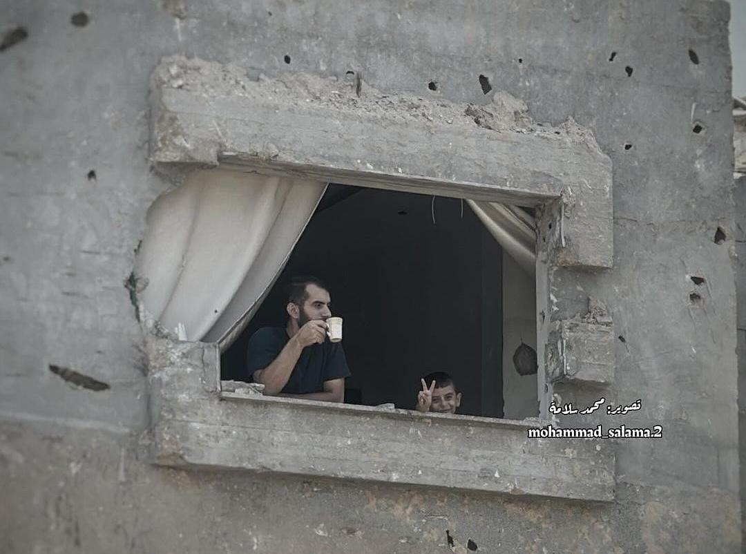 Palestinian Man and Child Amid Destruction and Defiance