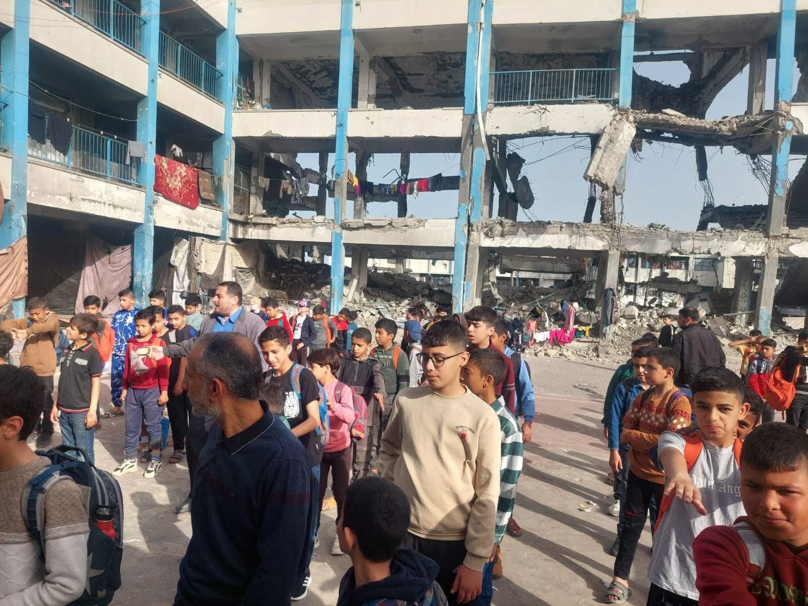 Destruction at a UNRWA school in Gaza as children stand amid rubble