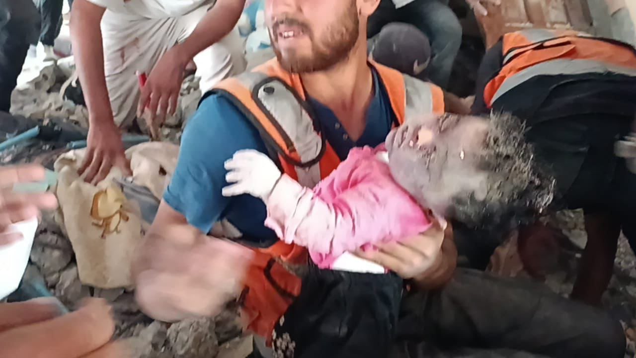 Child evacuation from bombed house in Deir al Balah