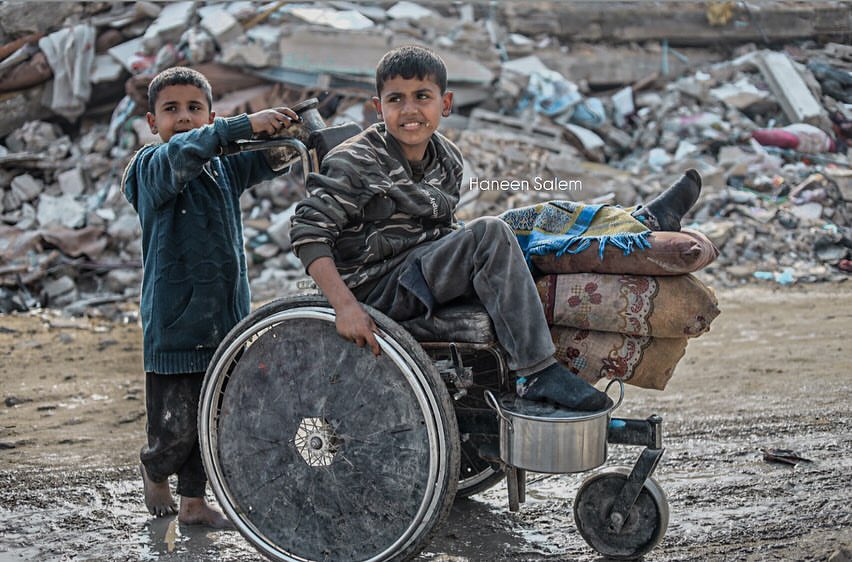 Child pushes wounded brother in makeshift cart in Gaza