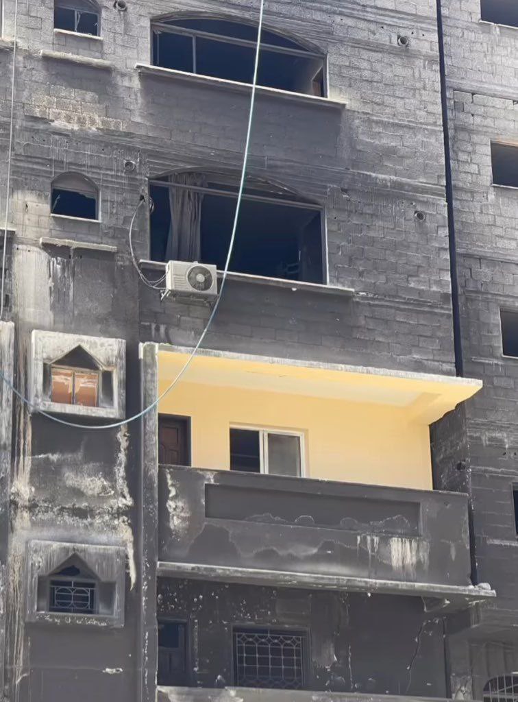 Palestinian repaints his house burned during Israeli attack in Gaza