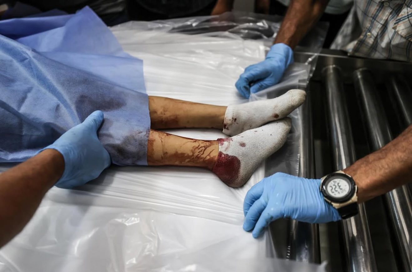 Medical staff prepare body of Palestinian child killed in Israeli attacks