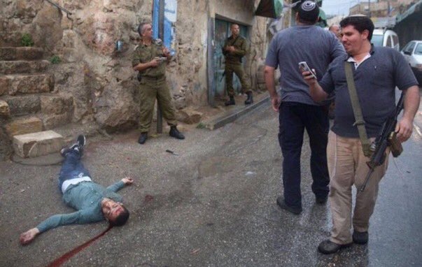Zionist settlers take photos after killing Palestinian boy