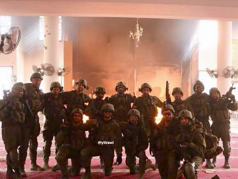 Israeli soldiers photograph burned mosque in Gaza City