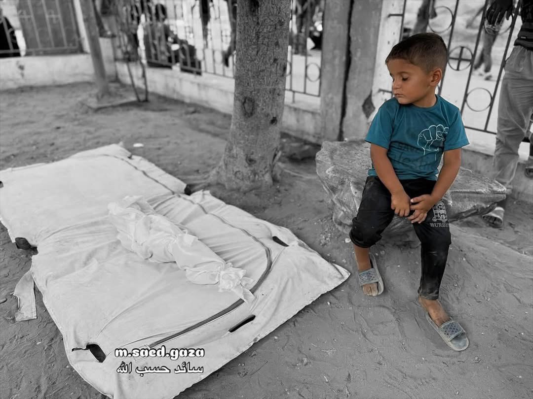 Child grieves beside martyred sibling in Gaza