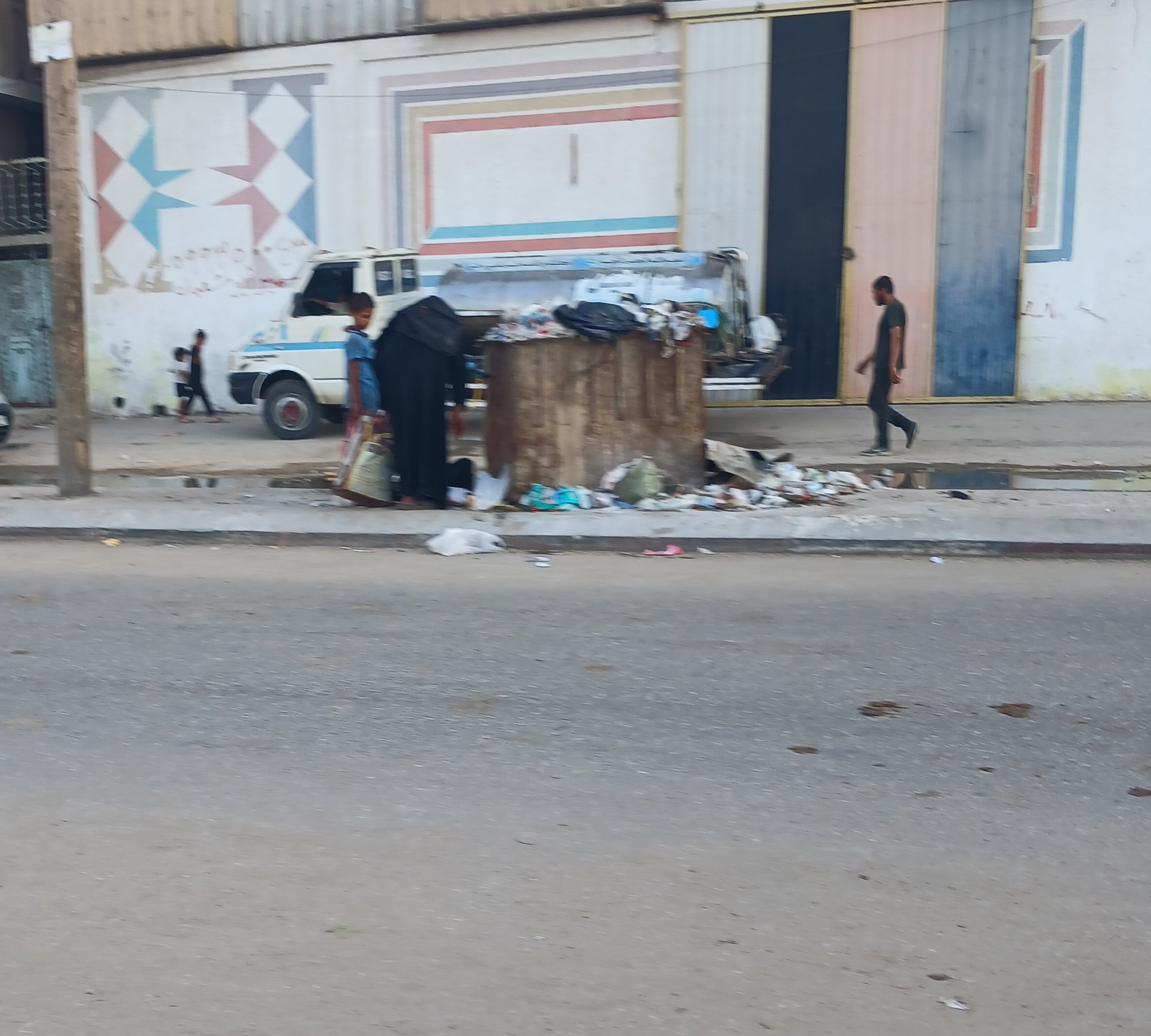 Mother and child searching garbage for food in Gaza famine