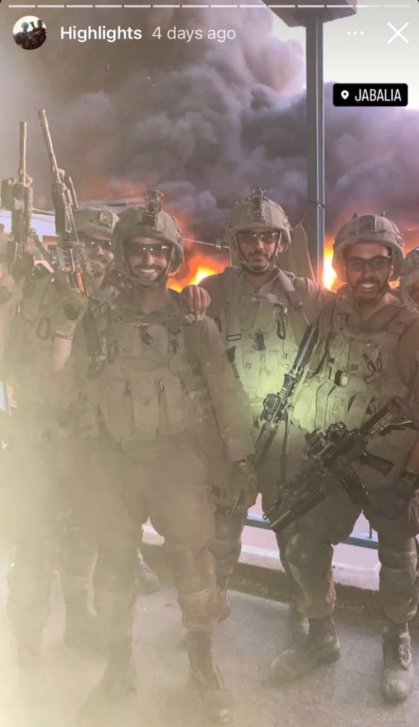 Israeli soldiers pose with burned Palestinian homes in Jabalia
