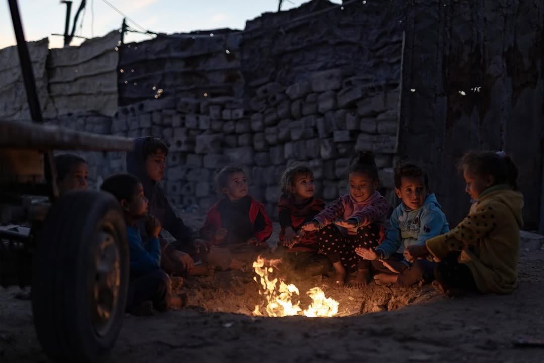 Palestinian children light fire to escape cold in Khan Yunis displacement camp
