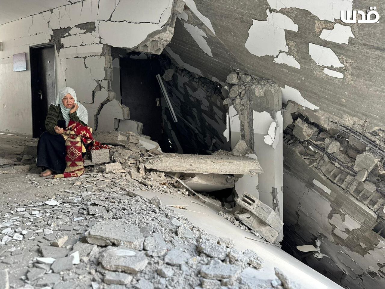 Palestinian woman inspects shop destroyed by Israeli airstrikes in Rafah