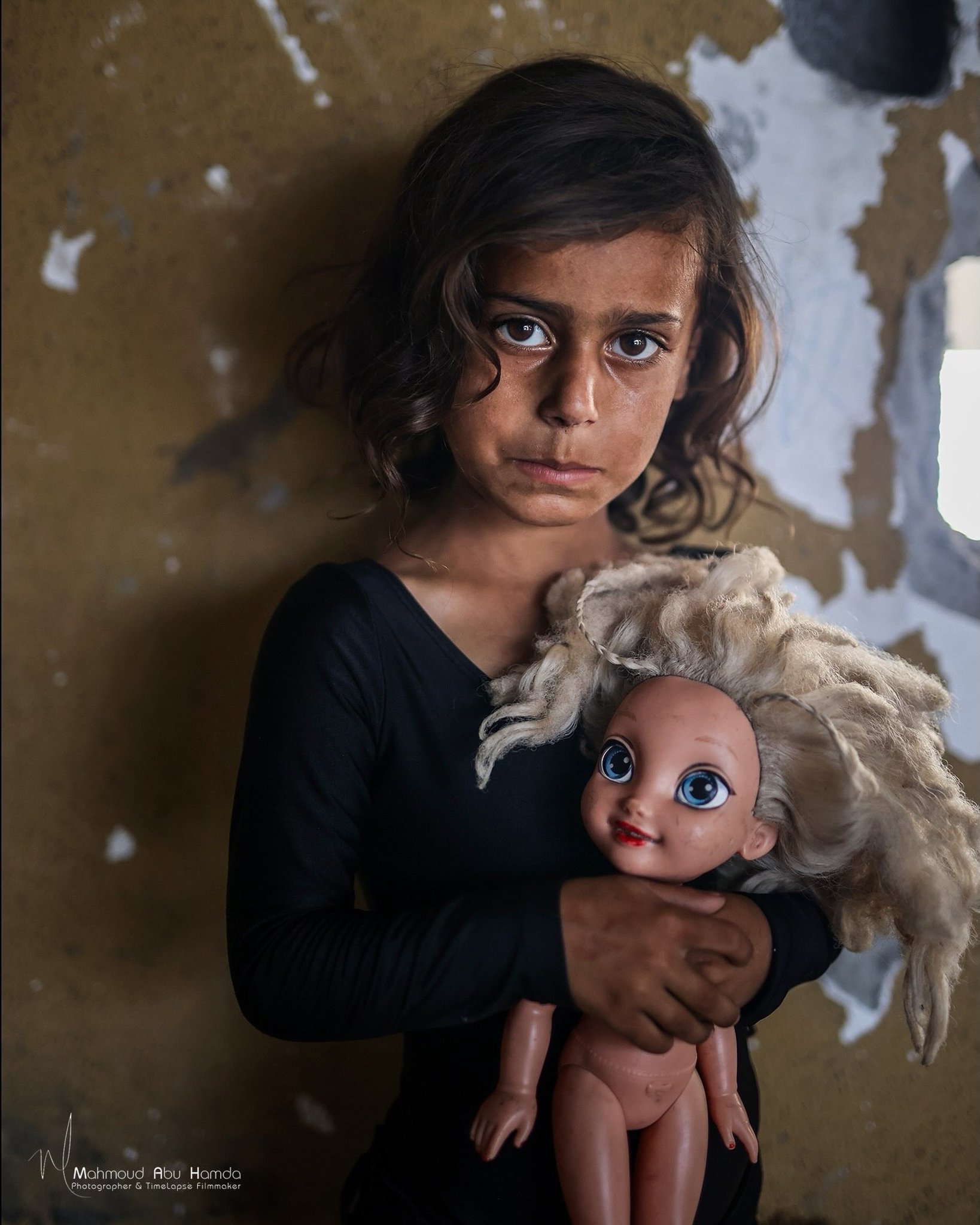 Gazan child embraces her only doll amid blockade and ruins