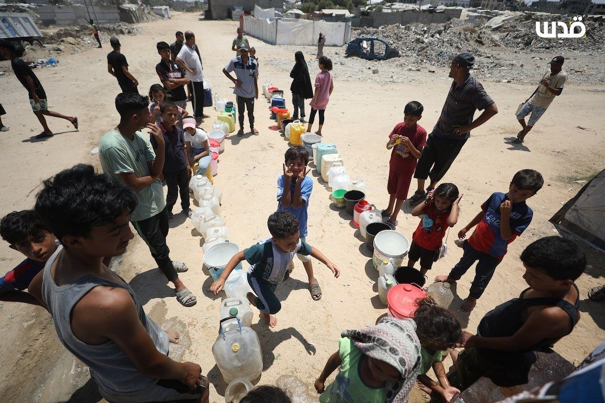 Displaced Palestinians queue for water at Nuseirat camp in Gaza