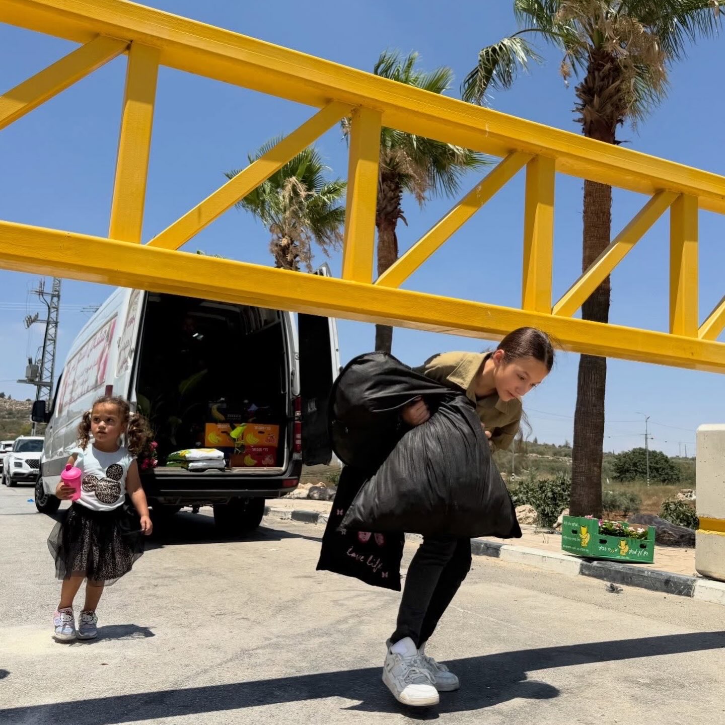 Palestinians pass closed Israeli military gate in Turmusaya, West Bank