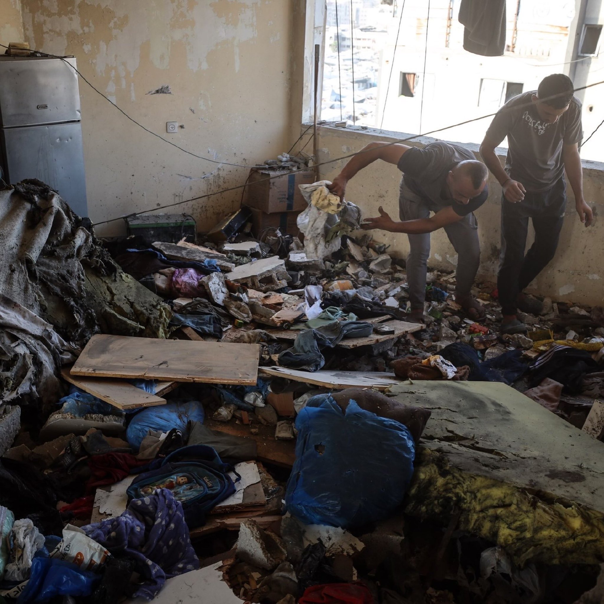 Palestinians inspect apartment damaged by Israeli airstrike in Gaza City
